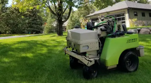 Lawn technician fertilizing a clients lawn in Detroit Lakes, MN.